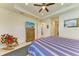 Bright main bedroom with a TV, ceiling fan, tile floors, and access to ensuite bathroom and walk-in closet at 15498 Seafoam Cir, Port Charlotte, FL 33981