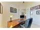 A home office features a wooden desk, comfortable chair, and tastefully framed artwork at 15498 Seafoam Cir, Port Charlotte, FL 33981