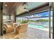 Inviting outdoor living space with a pool, luxurious seating, and built-in grill overlooking a waterfront view at 15498 Seafoam Cir, Port Charlotte, FL 33981