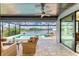 Outdoor patio features wicker furniture, a ceiling fan, and a view of the pool and waterway at 15498 Seafoam Cir, Port Charlotte, FL 33981