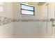 Elegant shower features white tiled walls and a mosaic accent at 15498 Seafoam Cir, Port Charlotte, FL 33981
