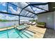 The backyard boasts a screened-in pool and spa with views of the lake and dock for the Gathering to enjoy at 15498 Seafoam Cir, Port Charlotte, FL 33981