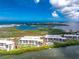 An aerial view showcases waterfront condos with lush landscaping, a pool, and serene water views in the background at 1701 Beach Rd # 207, Englewood, FL 34223