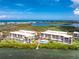 Aerial view of waterfront condos featuring a pool, dock, and beautiful landscape, with waterfront views at 1701 Beach Rd # 207, Englewood, FL 34223