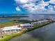 An aerial view of waterfront condos with a pool and boat dock, all set against a backdrop of blue water and sky at 1701 Beach Rd # 207, Englewood, FL 34223