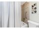Bathroom showcasing a tub with shower, tiled walls, and safety bar at 1701 Beach Rd # 207, Englewood, FL 34223