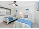 Bright bedroom features two twin beds, a ceiling fan, and serene decor, perfect for relaxation at 1701 Beach Rd # 207, Englewood, FL 34223