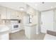 Efficient kitchen with white cabinetry, appliances, and a cozy breakfast bar at 1701 Beach Rd # 207, Englewood, FL 34223