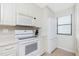 Charming kitchen with white appliances, bright window, and plenty of storage at 1701 Beach Rd # 207, Englewood, FL 34223