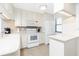 Well-lit kitchen featuring white appliances, ample counter space, and storage at 1701 Beach Rd # 207, Englewood, FL 34223