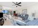 Spacious living room furnished with comfortable seating, ceiling fan, and water views beyond the balcony at 1701 Beach Rd # 207, Englewood, FL 34223