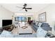 Comfortable living room featuring a ceiling fan, comfortable seating, and a view to the balcony at 1701 Beach Rd # 207, Englewood, FL 34223
