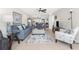 Bright living room with comfortable couches and chairs, connected to dining area and balcony at 1701 Beach Rd # 207, Englewood, FL 34223