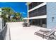 Large patio space offering lounge chairs, a table set, and beautiful views of palm trees at 1701 Beach Rd # 207, Englewood, FL 34223
