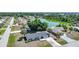 Picturesque aerial view of a quiet neighborhood with a serene pond and beautiful mature trees at 1730 Bluebird Ln, Englewood, FL 34224
