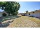 Large grassy backyard area with a view of the neighborhood homes and sunny blue sky at 1730 Bluebird Ln, Englewood, FL 34224