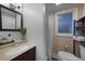 Cozy bathroom with a single sink vanity, framed mirror, window, toilet, and shower with curtain at 1730 Bluebird Ln, Englewood, FL 34224