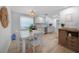 Inviting dining area bathed in natural light features modern décor and a view into a well-equipped kitchen at 1730 Bluebird Ln, Englewood, FL 34224