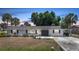 Charming single-story home boasting a well-manicured lawn, enhanced by lush landscaping and mature palm trees at 1730 Bluebird Ln, Englewood, FL 34224