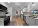 Bright kitchen with stainless steel appliances, white cabinetry, and a charming dining area at 1730 Bluebird Ln, Englewood, FL 34224