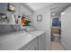 Bright laundry room with washer, dryer, shelving, and an open door to a half bathroom at 1730 Bluebird Ln, Englewood, FL 34224