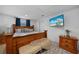 Well-lit bedroom featuring wood furniture, a comfortable rug, and a mounted TV at 1730 Bluebird Ln, Englewood, FL 34224