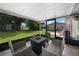 Covered patio with chairs, table, a view of the backyard, and a glimpse of the house's exterior at 1730 Bluebird Ln, Englewood, FL 34224