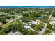 Aerial view of a home with lush landscaping, a pond, and located near the ocean at 1733 Belvidere Rd, Englewood, FL 34223