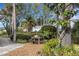 Backyard oasis with lush tropical plants, mature trees, and peaceful setting at 1733 Belvidere Rd, Englewood, FL 34223