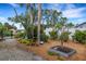 Landscaped backyard featuring decorative plants and trees along a gravel path at 1733 Belvidere Rd, Englewood, FL 34223