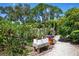 Lush backyard garden with tropical plants and decorative planters along a stone path at 1733 Belvidere Rd, Englewood, FL 34223