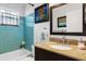 Stylish bathroom featuring blue tiling, a granite countertop vanity, and a stained glass window at 1733 Belvidere Rd, Englewood, FL 34223