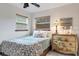 Comfortable bedroom featuring a patterned bedspread, palm tree dresser, and natural light at 1733 Belvidere Rd, Englewood, FL 34223