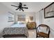 Cozy bedroom with a floral bedspread, a decorative dresser, and a wicker chair at 1733 Belvidere Rd, Englewood, FL 34223