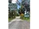 View of the entrance to the South Venice Lemon Bay Preserve along a sandy road with lush trees at 1733 Belvidere Rd, Englewood, FL 34223