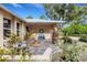 Charming porch with stone flooring, water feature, blue bench, and potted plants at 1733 Belvidere Rd, Englewood, FL 34223