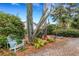 Front yard showcasing desert-style landscaping, a decorative chair and mature trees at 1733 Belvidere Rd, Englewood, FL 34223