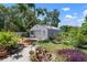 Exterior view of garage featuring metal roof and ladder and surrounding greenery at 1733 Belvidere Rd, Englewood, FL 34223