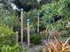 A lush garden featuring decorative poles with blue glass orbs and a variety of plants at 1733 Belvidere Rd, Englewood, FL 34223