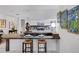 Open kitchen with a bar area, white cabinets, stainless steel appliances, and access to other living areas at 1733 Belvidere Rd, Englewood, FL 34223