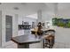 Modern kitchen with white cabinetry, stainless steel appliances, tiled countertops and barstool seating area at 1733 Belvidere Rd, Englewood, FL 34223