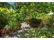 Lush landscaping with winding stone pathway and a variety of green plants and trees at 1733 Belvidere Rd, Englewood, FL 34223