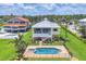 Aerial view of a two-story yellow home, a pool, and a lush green lawn at 1784 Bayshore Dr, Englewood, FL 34223