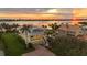 Aerial view showcasing a yellow waterfront home with lush lawn at 1784 Bayshore Dr, Englewood, FL 34223