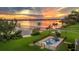 Aerial view of an in-ground swimming pool and hot tub with waterfront views at sunset at 1784 Bayshore Dr, Englewood, FL 34223