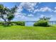 Picturesque backyard with lush green grass overlooking the tranquil bay waters at 1784 Bayshore Dr, Englewood, FL 34223