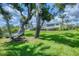 Spacious backyard with lush green lawn, mature trees and a charming yellow house in the background at 1784 Bayshore Dr, Englewood, FL 34223