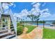 Beautiful outdoor space with a paved path leading to the pool and lush landscaping by a yellow home at 1784 Bayshore Dr, Englewood, FL 34223