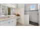 Bright bathroom featuring marble countertops, patterned floors, shower with glass door, and stylish decor at 1784 Bayshore Dr, Englewood, FL 34223