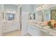 Elegant bathroom featuring dual marble vanities, stylish mirrors, floral wallpaper and patterned floors at 1784 Bayshore Dr, Englewood, FL 34223